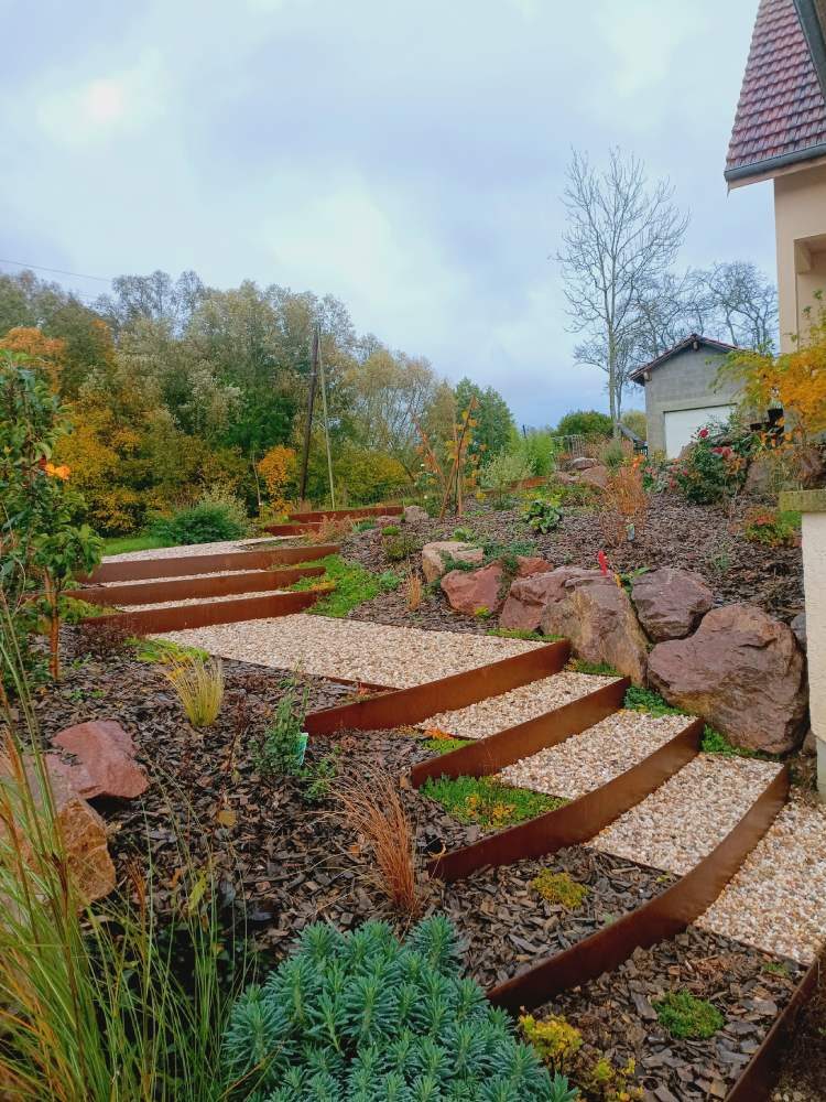 Escalier courbe en acier corten dans un jardin en automne